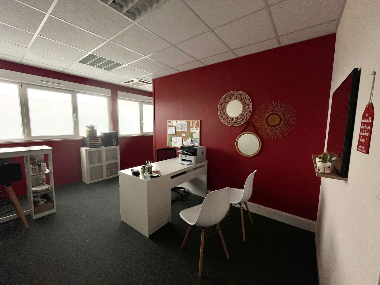 Un bureau du cabinet, mur bordeaux, table blanche et deux chaises